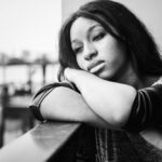 african american woman is sitting contemplating something