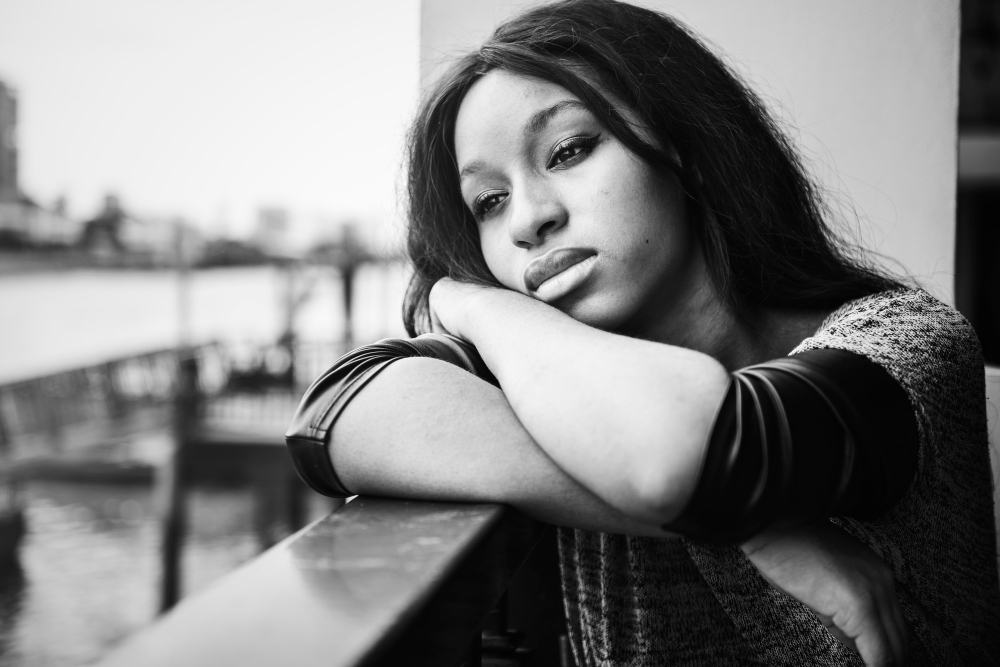 african american woman is sitting contemplating something